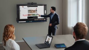 Modern meeting room with presenter using digital whiteboard and Dell collaboration devices